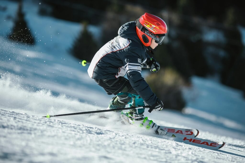 A skier in motion wearing winter gear, gliding swiftly down a snowy slope.